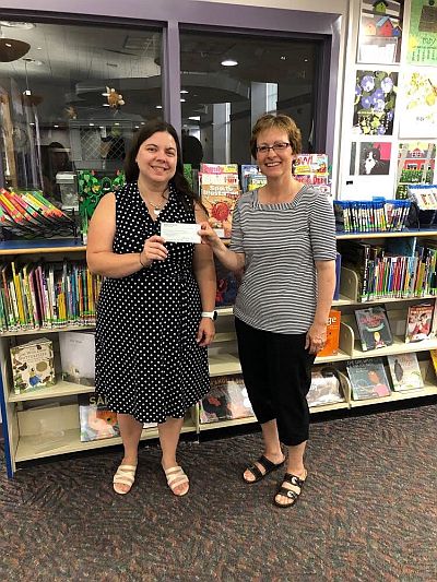 As a result of their hard work and donations to the Friends, Friends present a donation check to Canton Public Library's Director.